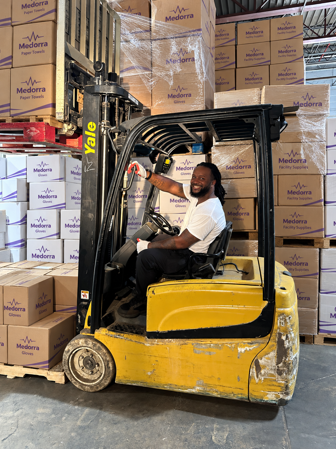 A Medorra warehouse team member on a forklift; packaging retouched for brand presentation